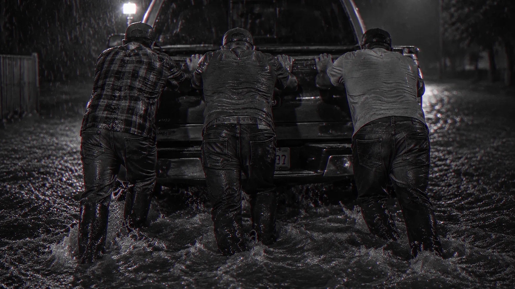 Men set their shoulders together against the same load.